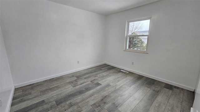 spare room featuring wood-type flooring