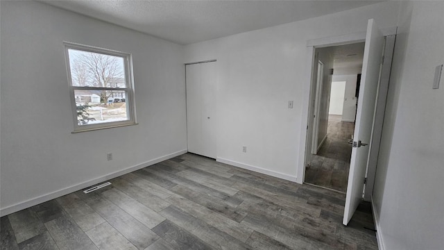 unfurnished bedroom with hardwood / wood-style flooring and a closet