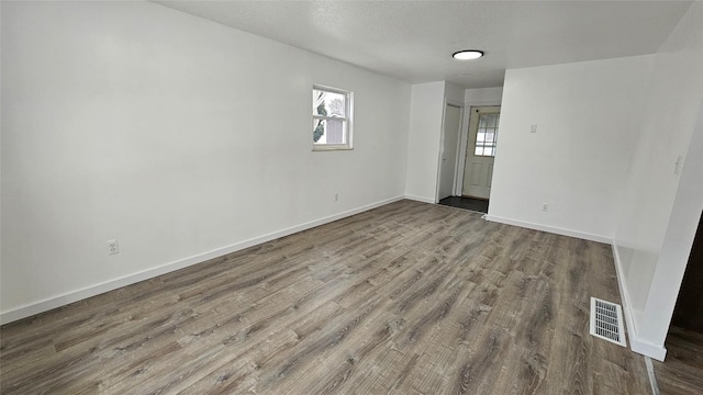 spare room with wood-type flooring and a wealth of natural light