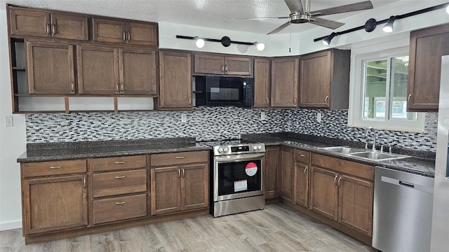 kitchen featuring stainless steel appliances, sink, decorative backsplash, and light wood-type flooring