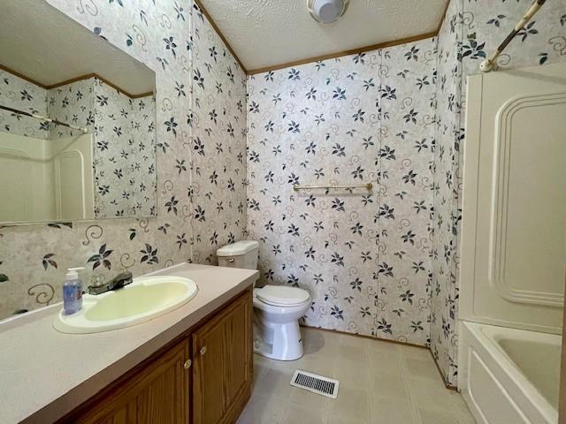 bathroom featuring wallpapered walls, visible vents, toilet, a textured ceiling, and vanity