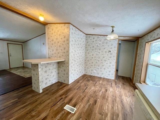 spare room featuring visible vents, a textured ceiling, and wood finished floors