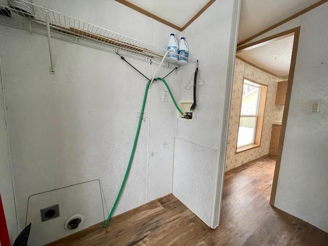 clothes washing area featuring laundry area, ornamental molding, and wood finished floors