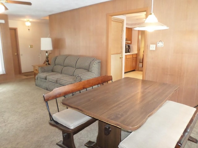 dining room featuring ceiling fan and light carpet