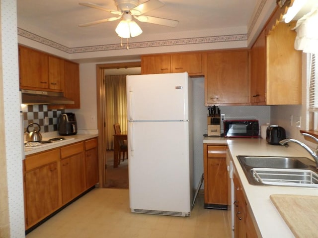 kitchen featuring ceiling fan, white appliances, sink, and decorative backsplash