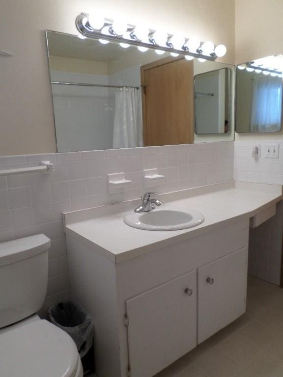 bathroom featuring toilet, tile walls, vanity, a shower with shower curtain, and tile patterned flooring