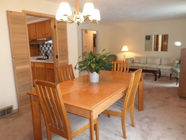 dining room featuring light colored carpet and a notable chandelier