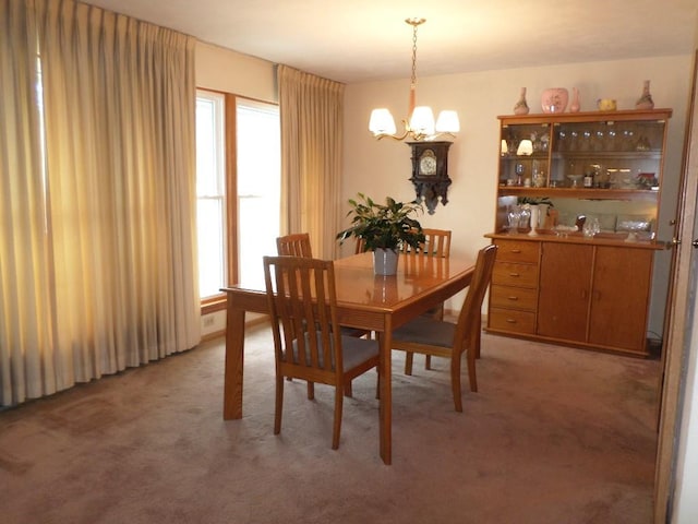 carpeted dining room featuring a chandelier