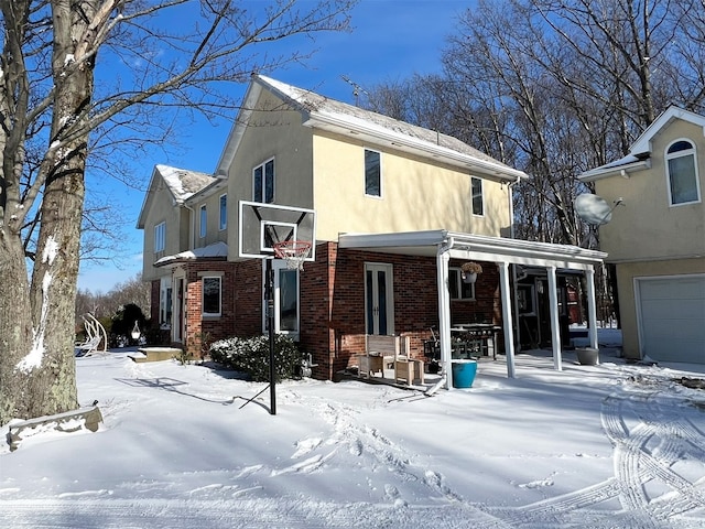 snow covered house featuring a garage