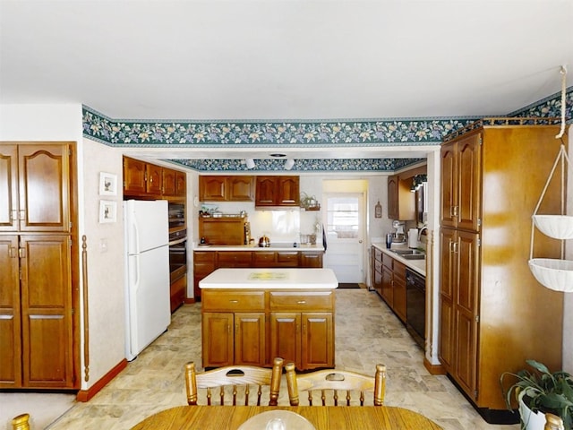 kitchen featuring black dishwasher, a center island, sink, and white fridge