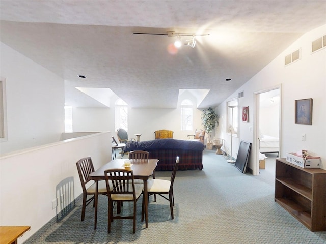 carpeted dining area with vaulted ceiling