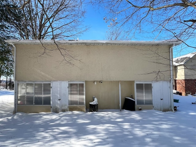 view of snow covered back of property