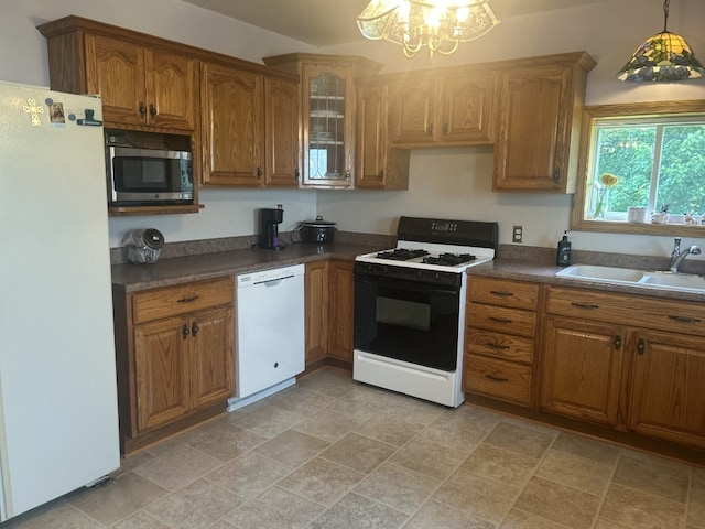 495 E Jamestown Rd, Greenville, PA 16125 - kitchen with white appliances, a chandelier, brown cabinets, dark countertops, and stone finish flooring