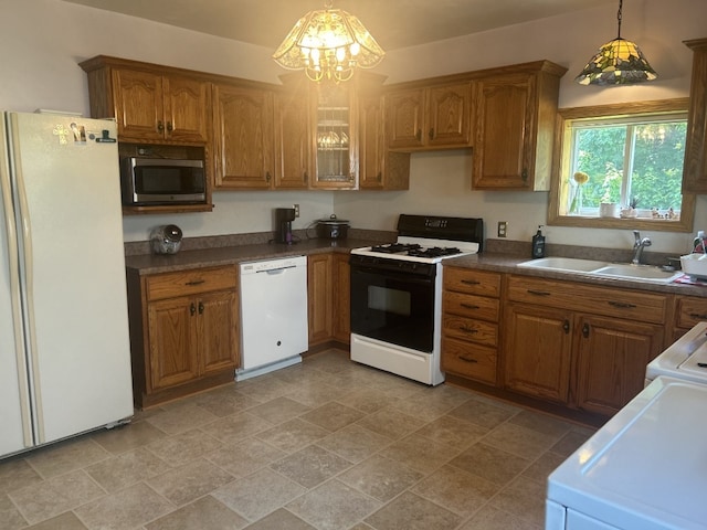 495 E Jamestown Rd, Greenville, PA 16125 - kitchen featuring white appliances, brown cabinetry, a chandelier, hanging light fixtures, and dark countertops