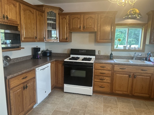 495 E Jamestown Rd, Greenville, PA 16125 - kitchen with white appliances, brown cabinetry, dark countertops, stone finish flooring, and glass insert cabinets