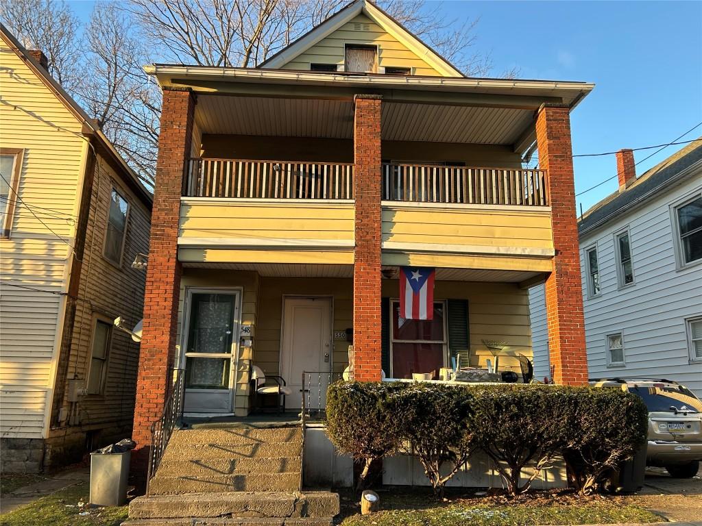 view of front facade with a balcony and a porch