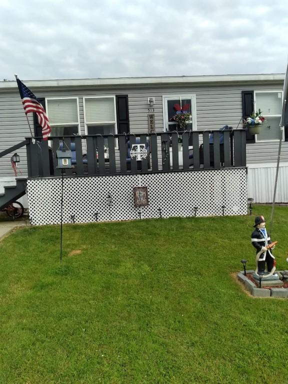 exterior space with a wooden deck and a lawn