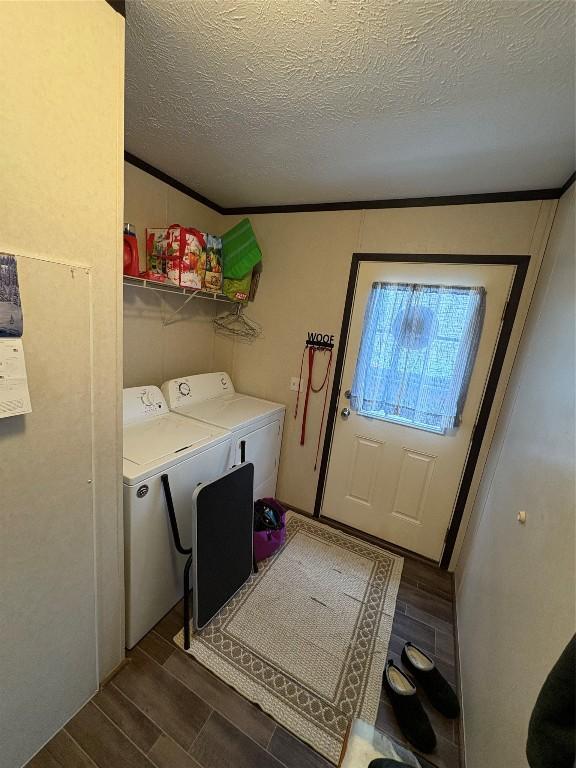 laundry room with a textured ceiling, washer and clothes dryer, and ornamental molding