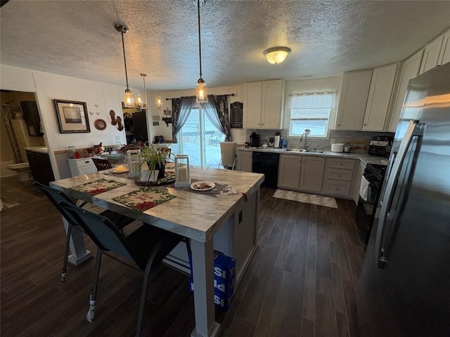 kitchen with a textured ceiling, black appliances, decorative light fixtures, dark hardwood / wood-style floors, and white cabinetry