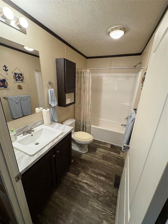 full bathroom with crown molding, wood-type flooring, a textured ceiling, toilet, and vanity