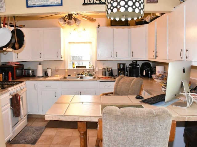 10987 Henry St, Conneaut Lake, PA 16316 - kitchen featuring white gas range, black microwave, white cabinets, and light tile patterned floors