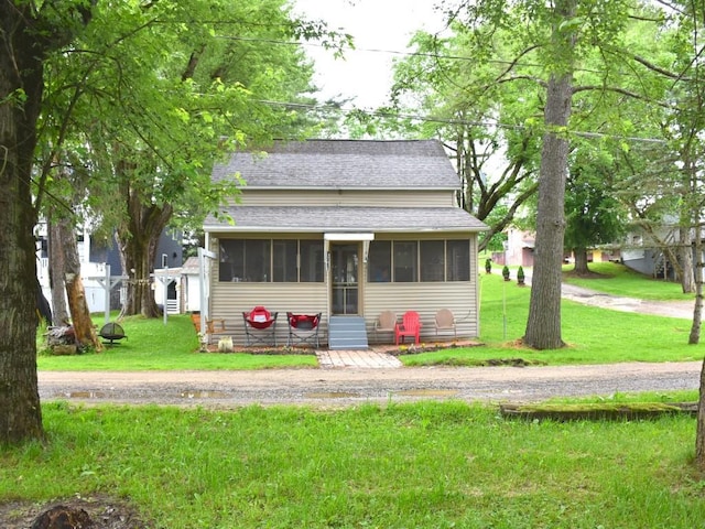 10987 Henry St, Conneaut Lake, PA 16316 - bungalow-style home with a shingled roof, a sunroom, and a front yard