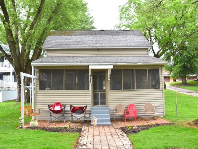 10987 Henry St, Conneaut Lake, PA 16316 - bungalow-style house with a sunroom, a shingled roof, and a front yard