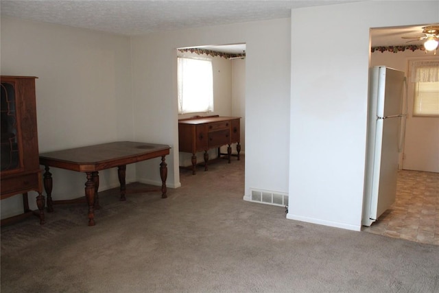 carpeted empty room with ceiling fan and a textured ceiling