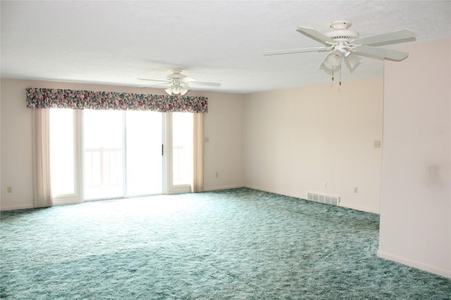 carpeted empty room with ceiling fan and a wealth of natural light