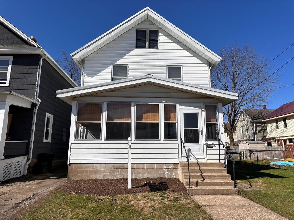 view of front of house featuring fence and a sunroom