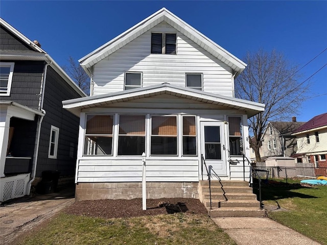 view of front of house featuring fence and a sunroom
