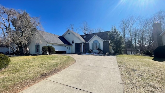 view of front of property featuring a front lawn, an attached garage, and concrete driveway