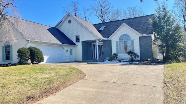 view of front of house featuring a front lawn, a garage, driveway, and roof with shingles