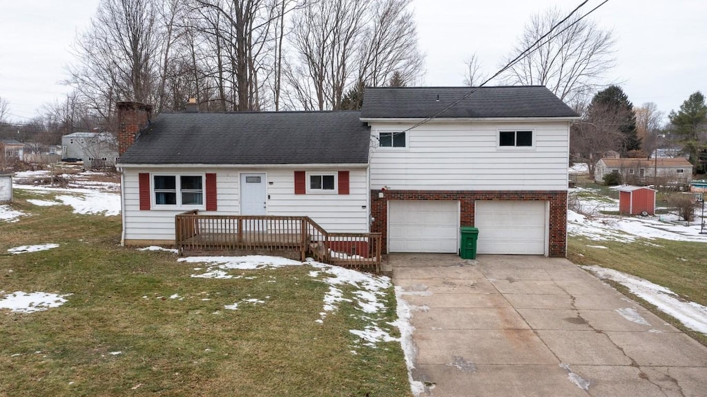 view of front of property featuring a yard, a garage, and a wooden deck