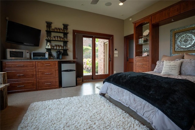 bedroom with access to exterior, refrigerator, and ceiling fan