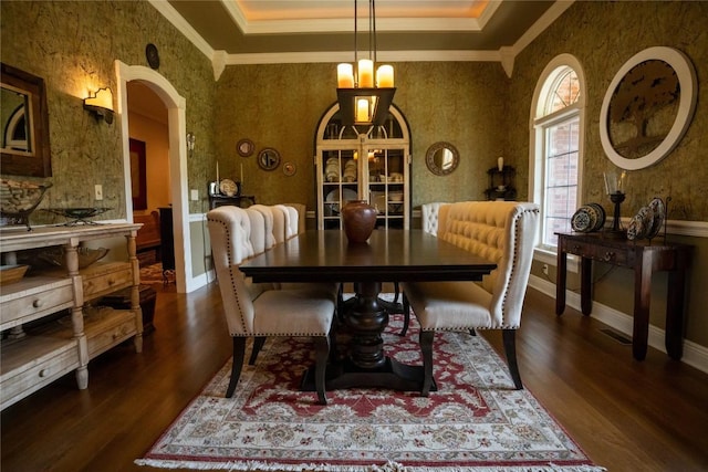 dining room featuring a wealth of natural light, a notable chandelier, dark hardwood / wood-style floors, and ornamental molding