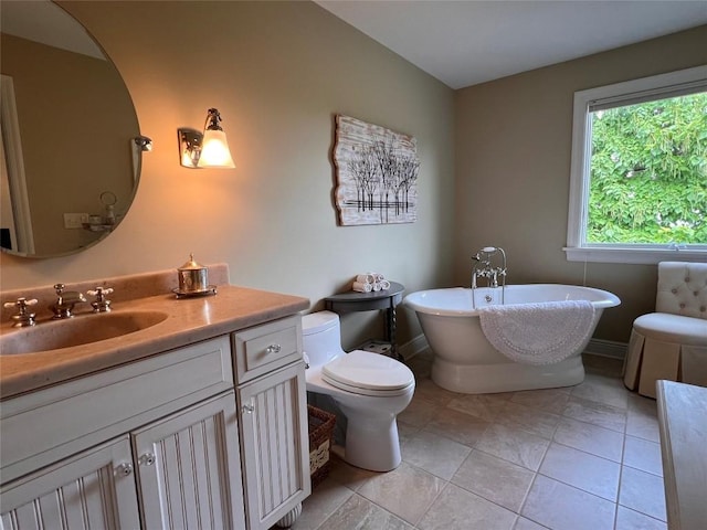 bathroom with tile patterned floors, a washtub, toilet, and vanity