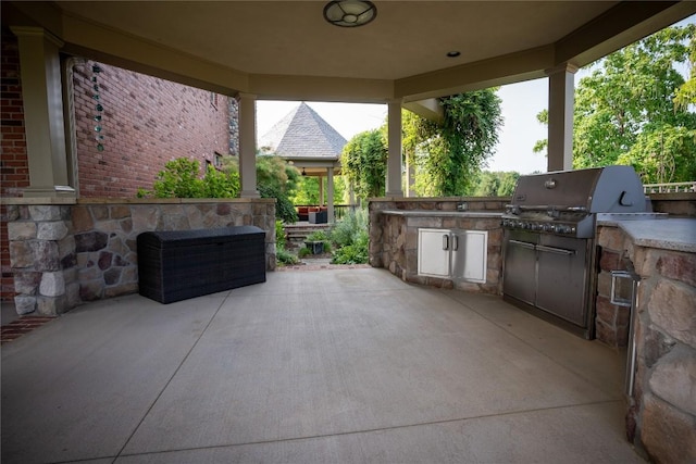 view of patio with area for grilling and a grill