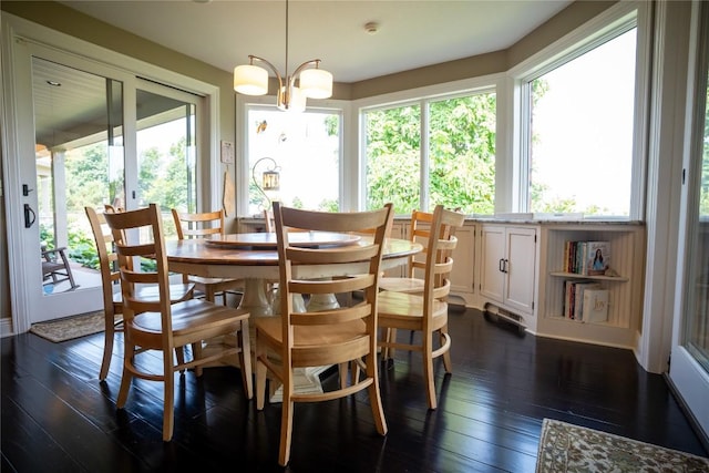 dining area featuring dark hardwood / wood-style floors, plenty of natural light, and a notable chandelier