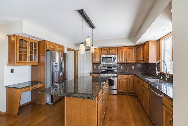 3706 Harbor Ridge Trl, Erie, PA 16510 - kitchen featuring stainless steel appliances, a sink, brown cabinetry, dark wood-style floors, and glass insert cabinets