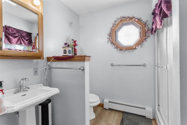 bathroom featuring wood-type flooring, toilet, and baseboard heating