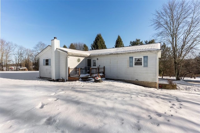 snow covered house with a wooden deck