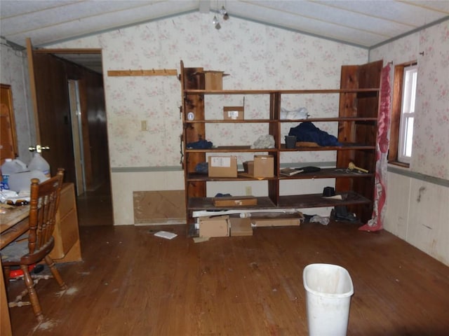 spare room with lofted ceiling, wainscoting, and wallpapered walls