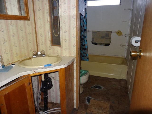 full bath featuring shower / bath combo, vanity, toilet, and wallpapered walls