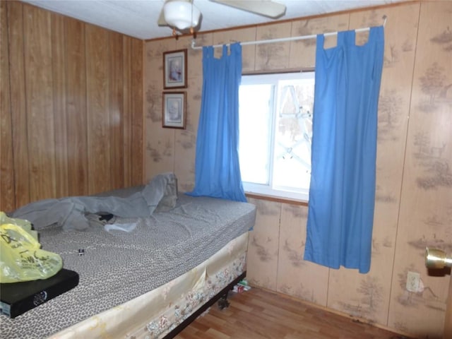 bedroom with wooden walls and wood finished floors