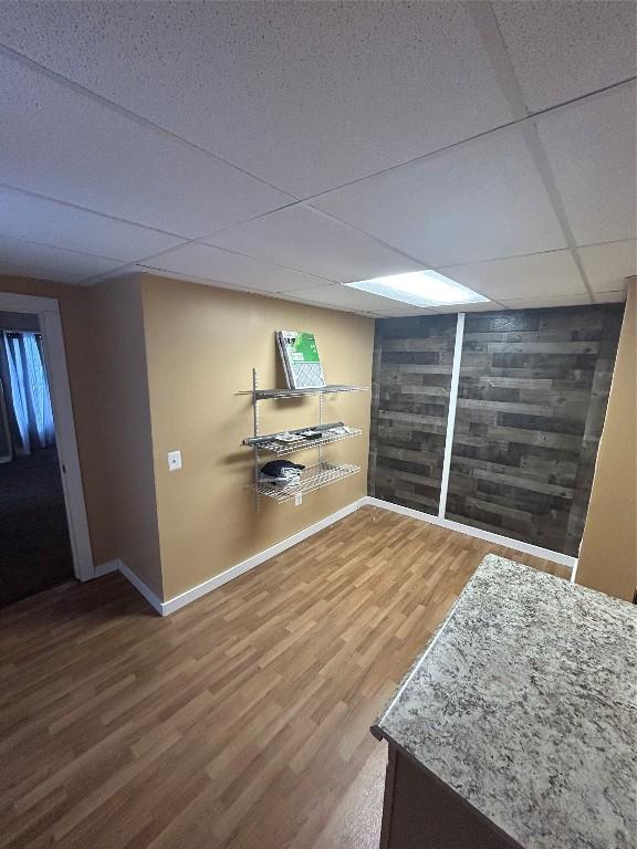 basement featuring hardwood / wood-style floors and a drop ceiling