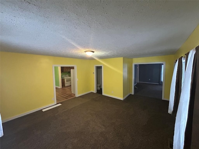 spare room with dark colored carpet and a textured ceiling