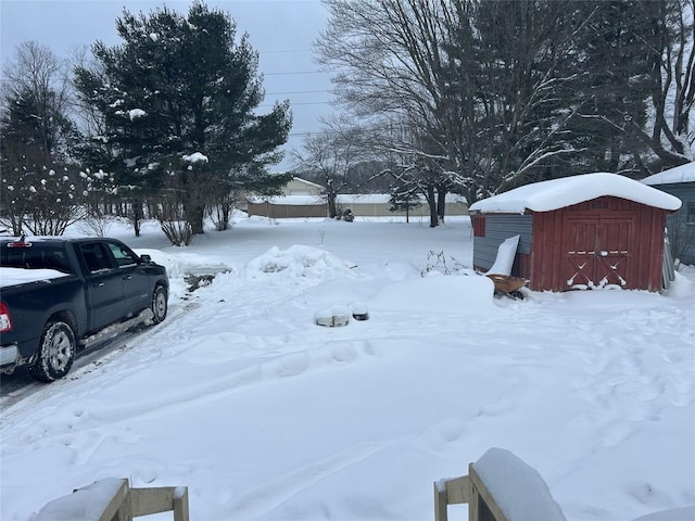 yard layered in snow with a shed