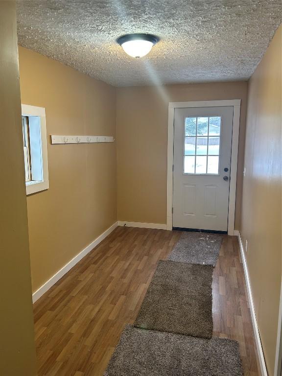 doorway featuring wood-type flooring and a textured ceiling