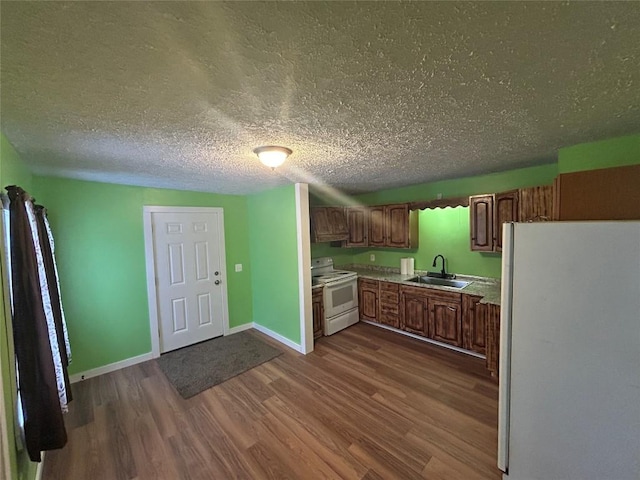 kitchen featuring sink, dark hardwood / wood-style flooring, ventilation hood, a textured ceiling, and white appliances